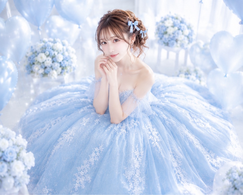 Sayaka seated in a blue celebration setting